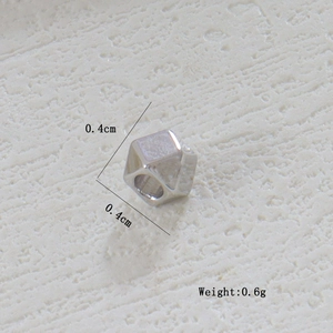 Vista macro de una cuenta de metal geométrica facetada de 0,4 cm para joyería DIY
