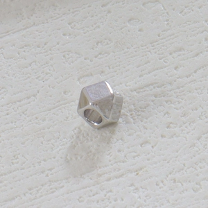 Primer plano de cuenta geométrica plateada para creación de joyas y collares DIY
