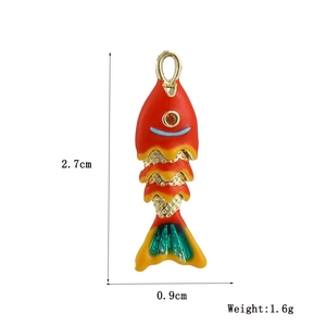 Vue détaillée d'un pendentif poisson rouge de 2,7x0,9 cm avec queue verte et écailles