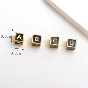 Detail of 0.6cm black enamel cube letter beads A to D with gold plating for DIY jewelry