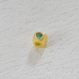 Detalle de la cuenta de cubo bañada en oro de 18k con piedra preciosa verde