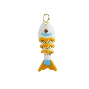 Détail d'un pendentif poisson en émail coloré avec écailles dorées et œil en gemme