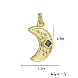 Detailed view of crescent moon pendant with central blue gemstone and gold finish