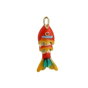 Détail macro d'un pendentif poisson en émail coloré avec des écailles articulées