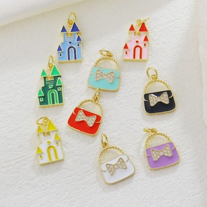 Detailed macro of enamel castle and crystal bow bag charms for DIY jewelry making