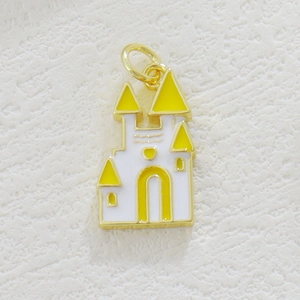 Close-up of 18k gold plated castle pendant with white and yellow enamel detailing