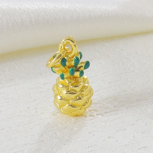 Macro detail of a gold-plated pineapple pendant with green enamel for DIY jewelry making