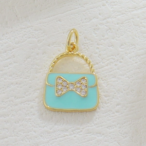 Macro detail of 18k gold plated blue enamel handbag charm with zircon bow