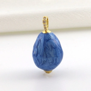 Makroaufnahme von blauem Marmor-Emaille-Anhänger mit Goldöse und Glitzer-Zirkonen