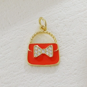 Detail of red enamel handbag charm with gold accents and sparkling crystal bowknot