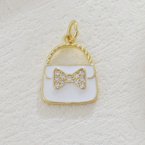 Detail of 18k gold-plated handbag pendant with white enamel and rhinestone bow