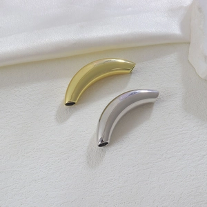 Nahaufnahme von polierten 18k Gold und Silber gebogenen Röhrenperlen für DIY-Schmuck