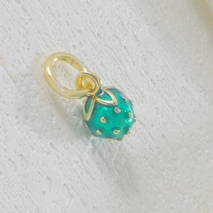 Detailed view of handmade strawberry pendant charm with green enamel and gold seeds
