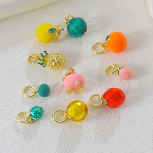 Detail of colorful fruit pendants in enamel and gold plating for DIY jewelry making