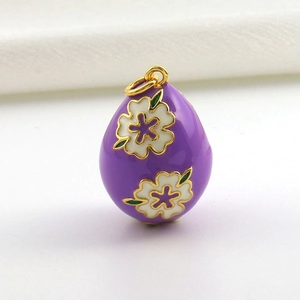 Detail eines violetten Emaille-Eianhängers mit weißen Blumen und 18k Goldbeschichtung