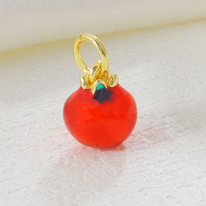 Macro view of persimmon pendant with red enamel finish and 18k gold plated details