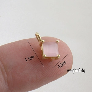 Detail showing pink zircon square pendant in gold plating with dimensions 1.1cm x 0.8cm