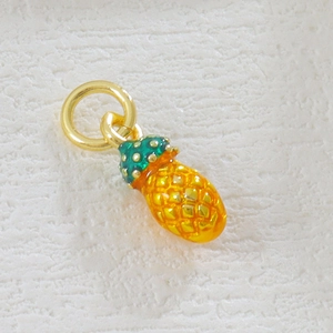 Detailed view of handmade pineapple charm with 18k gold plating and colorful enamel detail