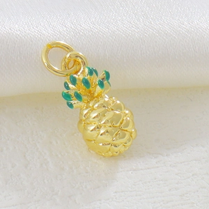 Detailed macro view of pineapple pendant with 18k gold plating and green enamel leaves