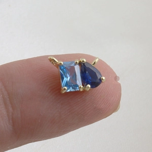 Detailed view of luxury gold pendant with blue rectangular and teardrop zircon stones