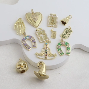 Detailed view of 18k gold plated charms including enamel horseshoe and diamond heart