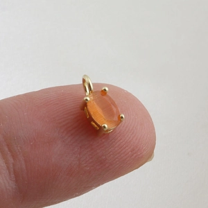 Detailed macro view of an 18k gold plated pendant with an orange cat-eye stone