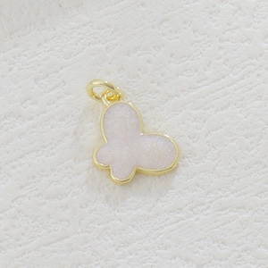 Detail view of 18k gold plated butterfly pendant with pink glitter inlay for jewelry diy