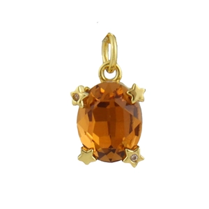Macro shot of oval amber stone pendant with gold star accents and cubic zirconia