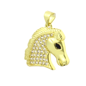 Détail d'un pendentif tête de cheval plaqué or 18k avec cristaux brillants blancs et noirs