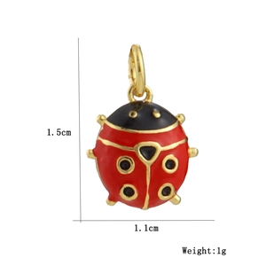 Detailed size view of a 1.5cm red ladybug pendant with 18k gold plating and enamel