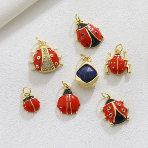 Detailed view of red enamel ladybug charms and blue teardrop pendant for jewelry DIY