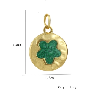 Detailed view of a round 18k gold star charm with green enamel and size measurements