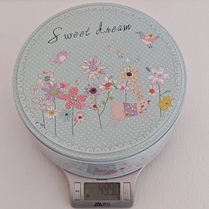 Vue détaillée d'une boîte de Pâques ronde sur une balance indiquant un poids de 499g