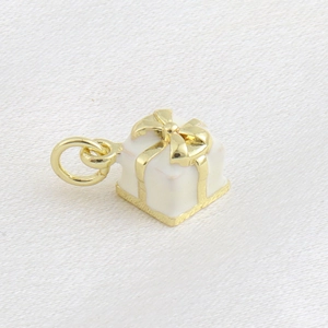Vue détaillée d'un pendentif boîte cadeau en émail blanc avec ruban doré 18 carats