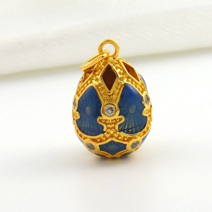 Close-up of gold-plated Easter egg pendant with blue enamel and sparkling zircons