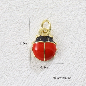 Macro view of 18k gold-plated ladybug pendant showing 1.5cm length and red enamel details