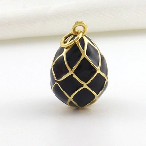 Detailed close-up of egg-shaped pendant with black enamel and golden grid pattern