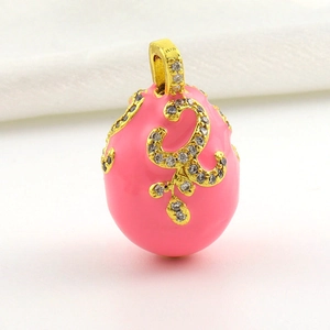 Macro shot of 18k gold plated pink enamel Easter egg pendant with zircon stones