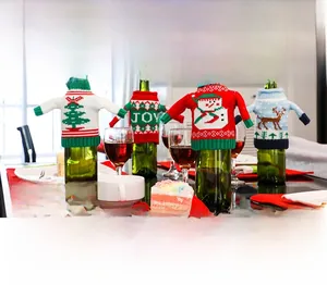 Close-up of festive knitted wine bottle sweaters with mini hats and Christmas patterns