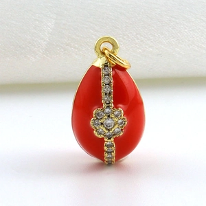 Detail van rode emaille Russisch ei hanger met verguld metaal en witte zirkoon kruis