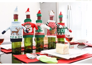 Detailed set of five festive knit Christmas sweater wine bottle covers on a dinner table