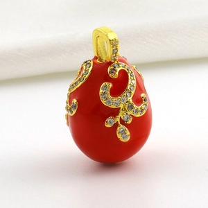 Macro view of red Fabergé style egg pendant with 18k gold plating and crystals