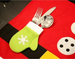 Close-up of green mitten cutlery holder and Santa themed placemat for Christmas decor
