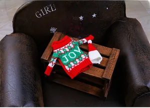 Close-up of knitted red Christmas wine bottle sweater with JOY text and matching hat