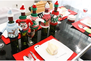 Detail view of 5-piece knitted Christmas wine bottle covers with mini sweaters and hats