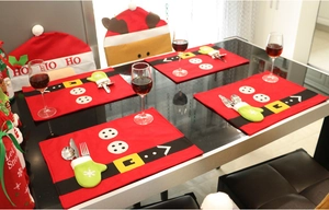 Festive Christmas table setting with Santa themed placemats and chair covers decoration