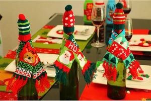 Close-up of festive knitted wine bottle hats and scarves with HO HO HO holiday patterns
