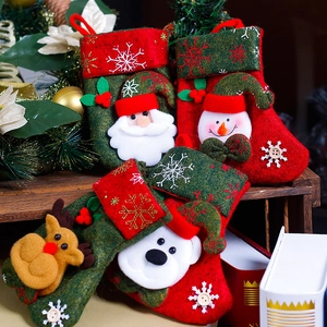 Set of 4 Christmas stockings with Santa, snowman, reindeer and bear on a wooden shelf