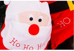 Dettaglio del sacchetto regalo di Natale in velluto rosso con ricamo Babbo Natale e peluche