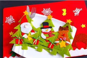 Detail of Christmas tree felt cutlery holders with Santa, snowman and reindeer on a plate
